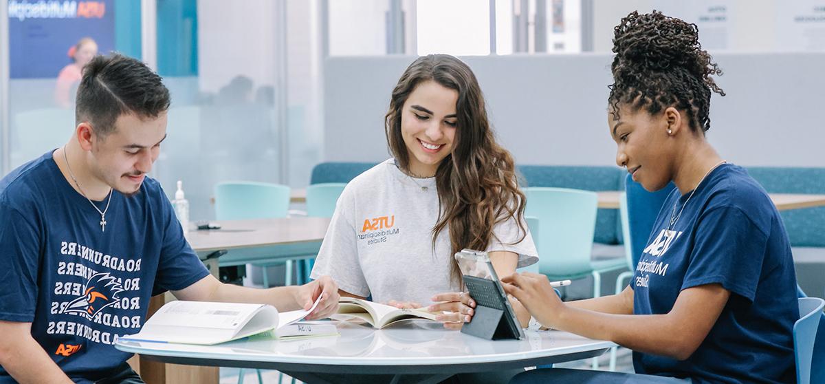 Students studing spanish at a table on campus.